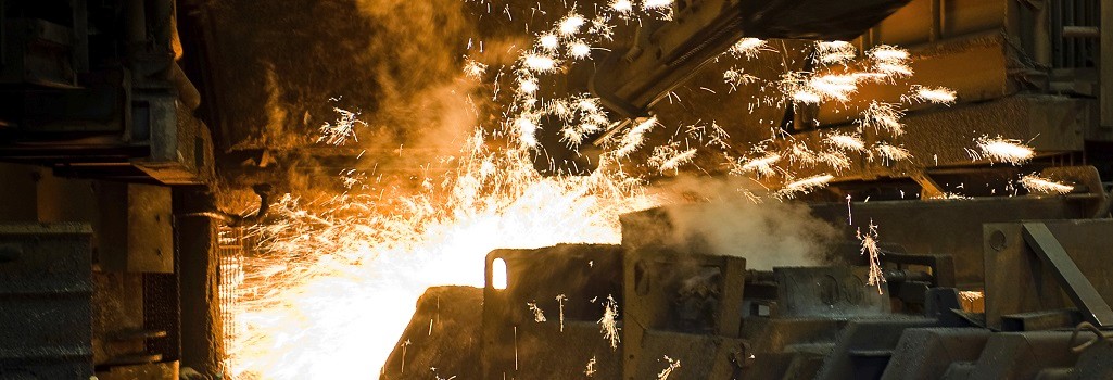 Huge drill creating a pouring hole in an industrial furnace - sparks flying everywhere